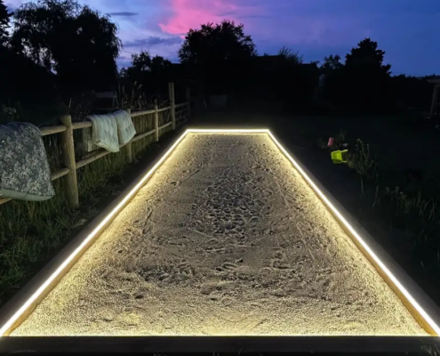 Terrain de pétanque éclairé à la tombée de la nuit